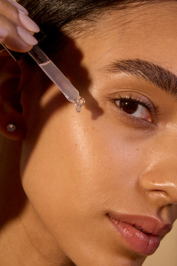 Woman applying serum with a dropper